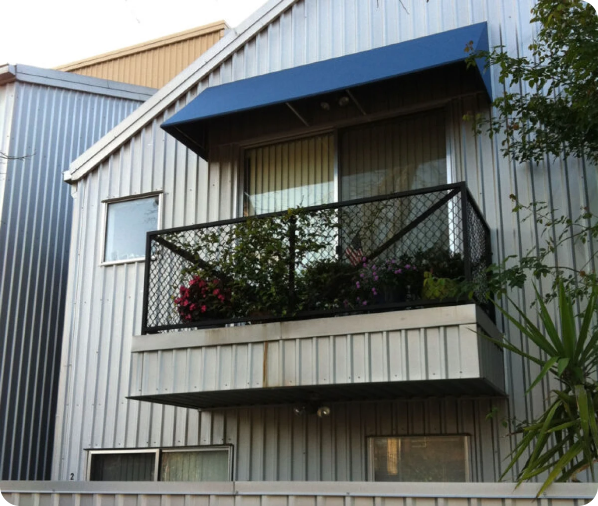 House exterior with balcony and plants.
