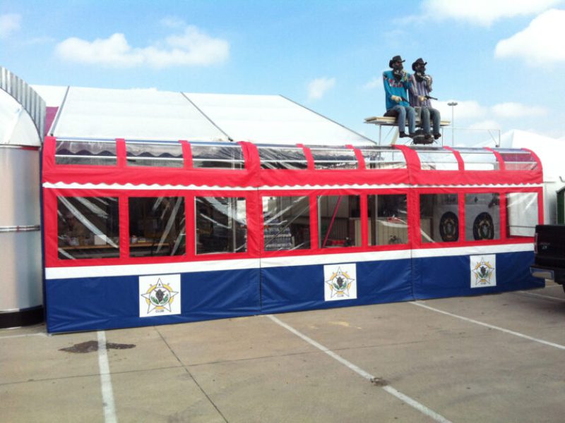 Red and blue tent with rooftop figures.