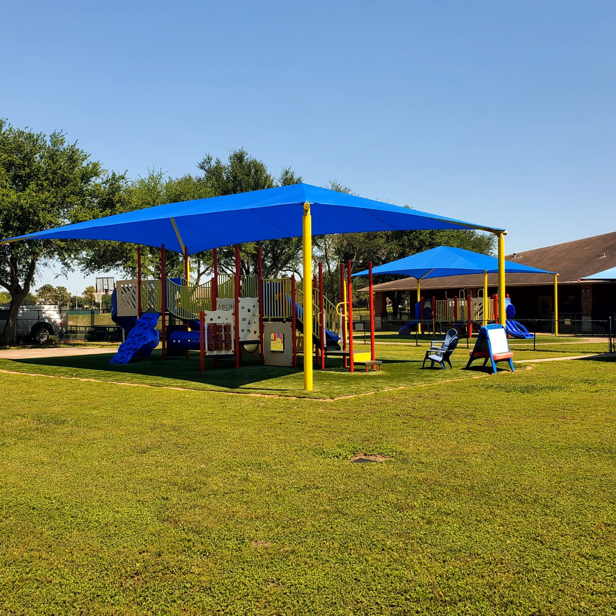Playground with blue shade structures on a sunny day.